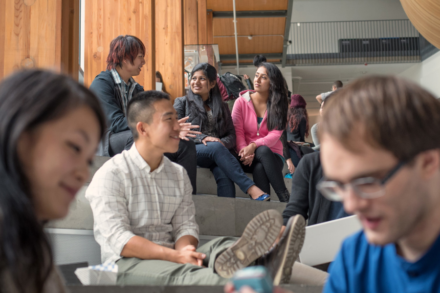 students sitting on the steps at the Nest talking